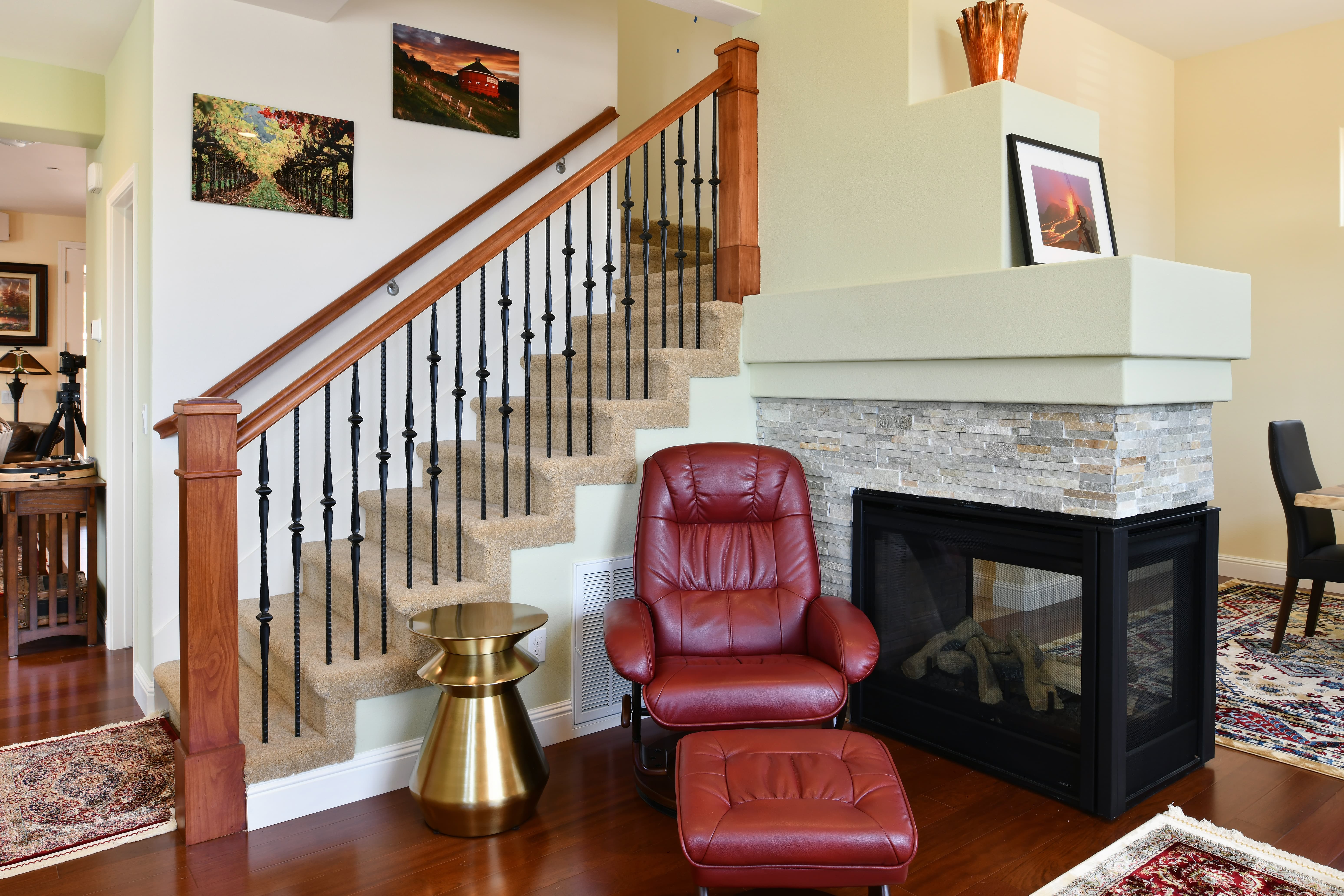 Living room with custom staircase and stone fireplace